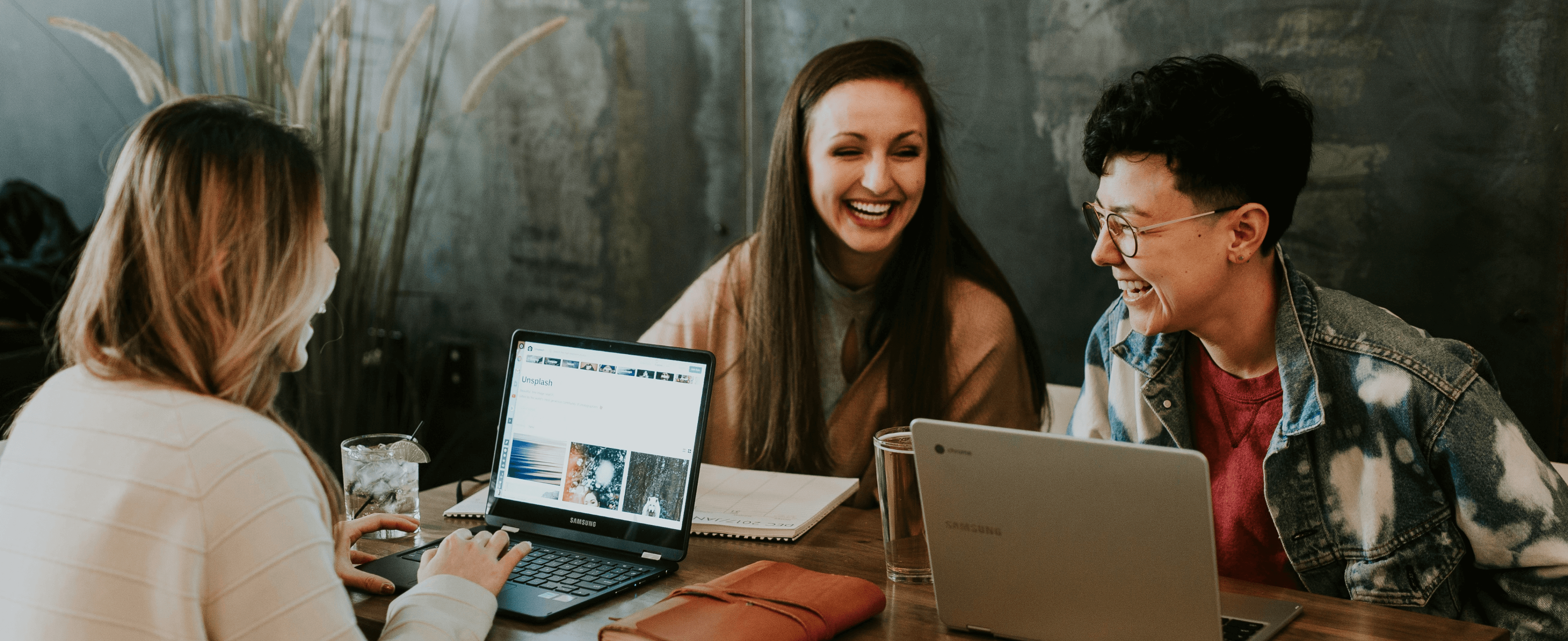 happy people on their laptops at a table