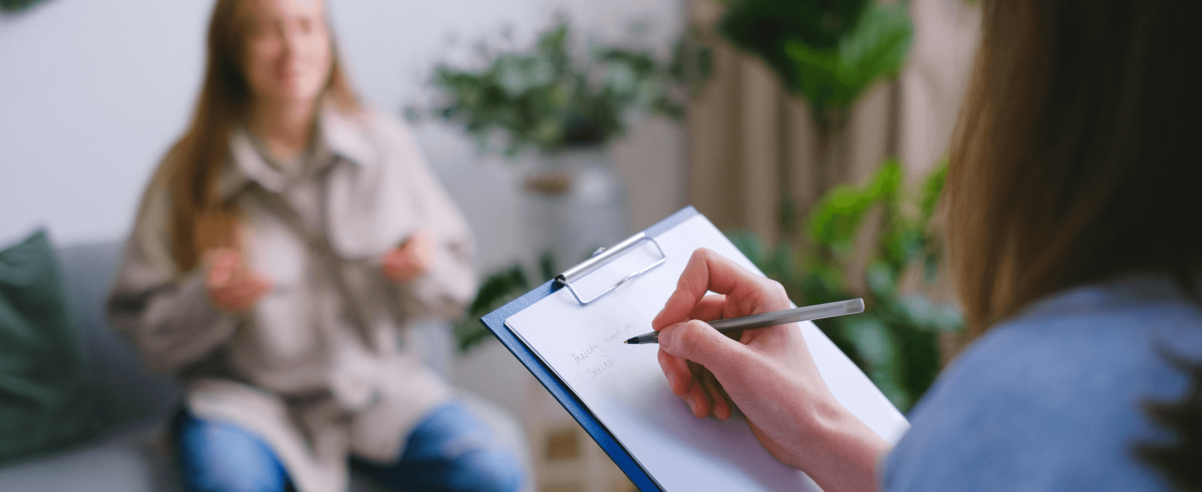 Healtcare practitioner taking notes during an appointment