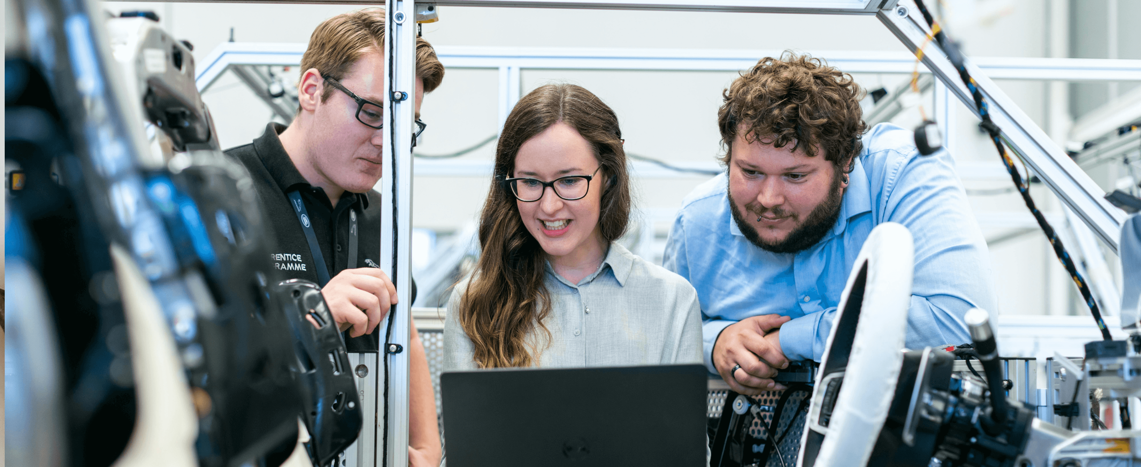 3 coworkers looking at a laptop in a warehouse